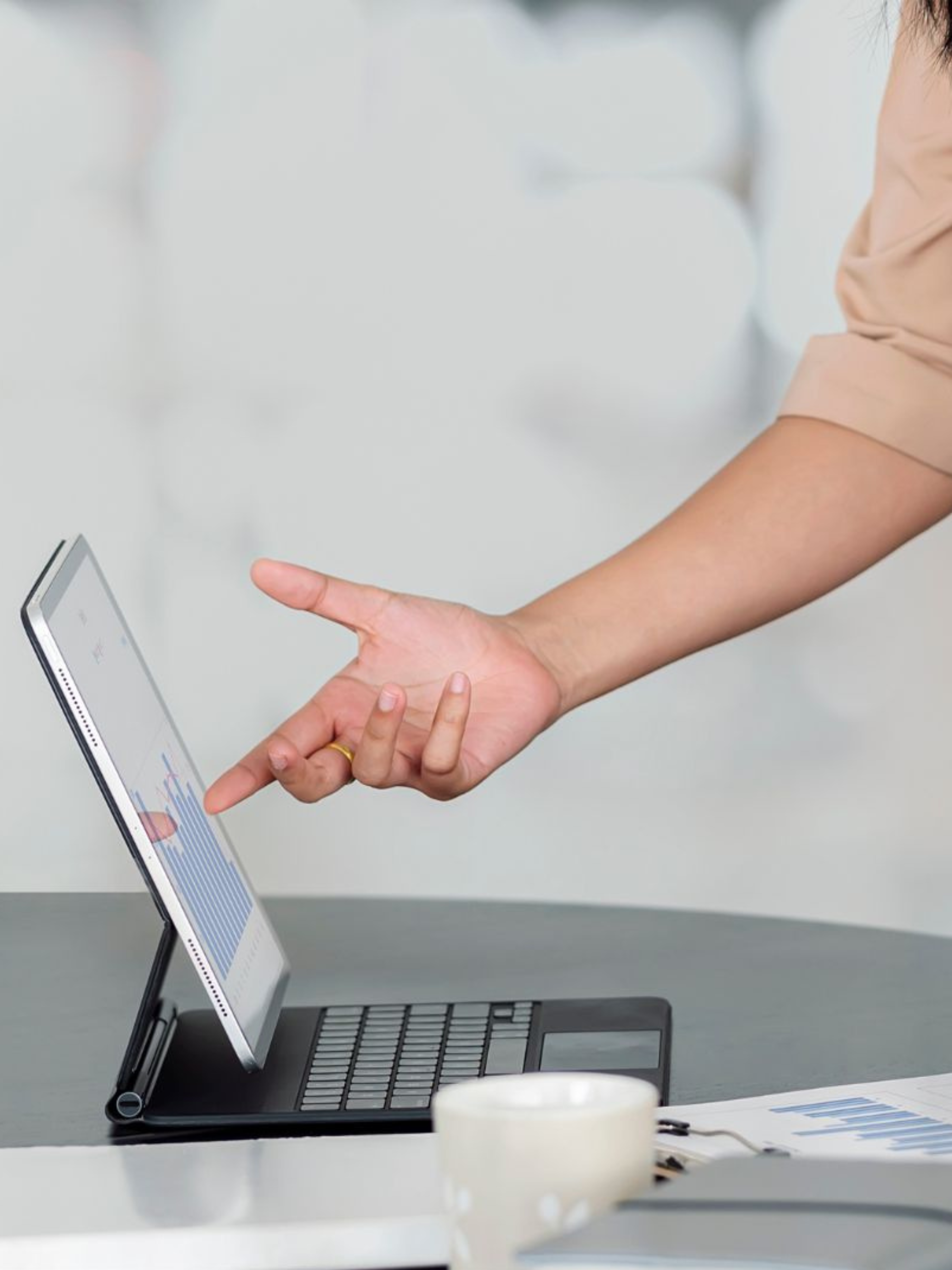 person pointing at a chart on a laptop